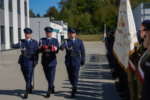 zdjęcie pocztu sztandarowego przedstawiają trzyosobową grupę dowódcę, sztandarowego i asystę