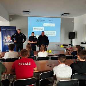 umundurowani policjanci w sali przed dziećmi podczas prelekcji