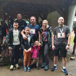 uczesnicy biegu z umundurowanym policjantem