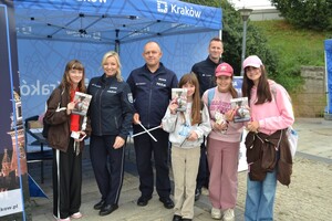Policjanci wraz z dziewczynami trzymają w ręku ulotki
