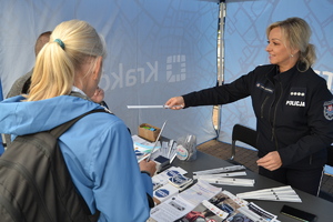 Policjantka wręcza element odblaskowy