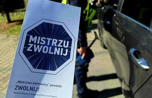 ulotka z napisem mistrzu z wolnij, w tle policjant kontroluje zatrzymany pojazd