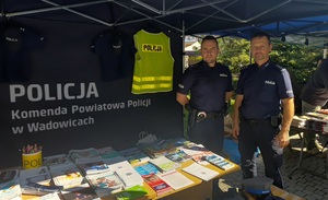 Dwóch policjantów obok stoika z ulotkami.