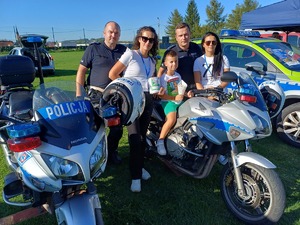 Dwóch policjantów  i uczestnicy pikniku na policyjnych motocyklach