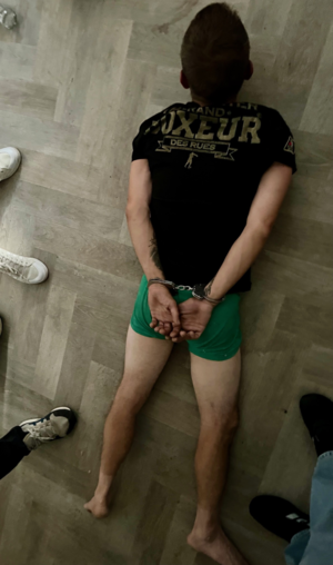 mężczyzna w kajdankach leżący na ziemi