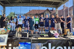 Na scenie grupa osób w tym umundurowani policjanci.