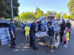 policjanci oraz uczestnicy wydarzenia przy stoisku profilaktycznym