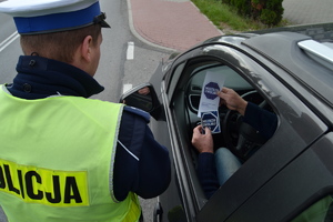 Policjant wręczający materiały informacyjne