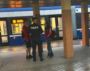 policjant rozmawia z osobami przy przystanku