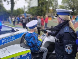 policjantka prezentująca dziecku policyjny motocykl