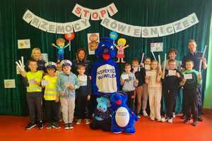 policjanci z uczniami i maskotkami policyjnymi