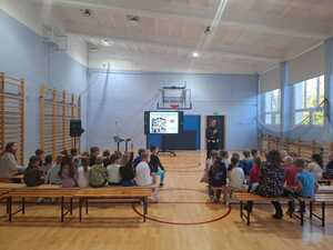 policjantka na sali gimnastycznej prowadzi dla dzieci zajęcia z bezpieczeństwa w ruchu drogowym