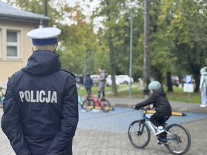 Policjantka nadzoruje dziecko na rowerze na egzaminie praktycznym