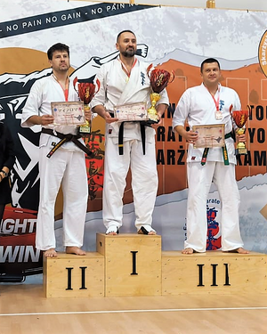 Podium zwodów w turnieju karate. Zawodnicy z pucharami, medalami i dyplomami