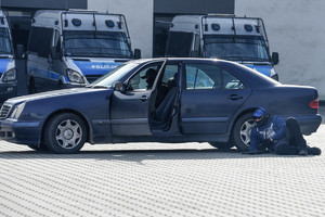 policjant grający zamachowca leżący przy samochodzie