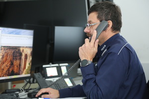dyżurny przy komputerze rozmawia przez telefon