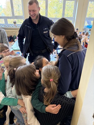 Dzieci przytulające policjantkę