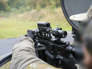 policjant strzela z włazu na dachu wozu opancerzonego