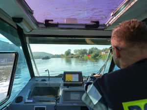 policjant steruje motorówką