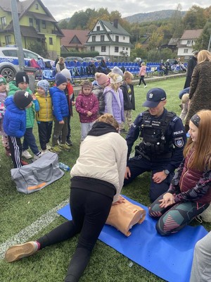 Policjant obserwujący dziewczynkę która uciska fantoma