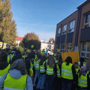 pochód uczniów w odblaskowych kamizelkach