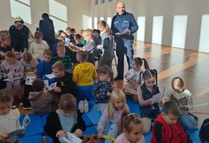 Policjanci rozdają kolorowanki oraz opaski odblaskowe