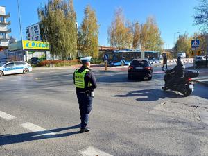 policjant czuwa na skrzyżowaniu na miejskim osiedlu