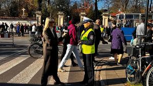 policjantka udziela wywiadu telewizji przed wejściem na cmentarz