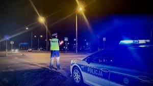 policjant pilnuje skrzyżowania po zmroku