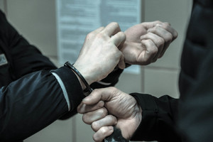 dłonie skute kajdankami