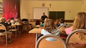 sala lekcyjna, placówka oświaty, w tle funkcjonariusz