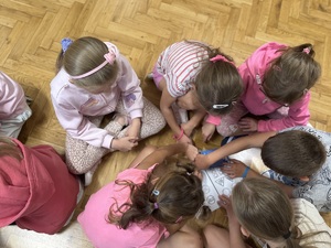 siedzące dzieci na podłodze rozwiązujące zadania z ruch drogowego