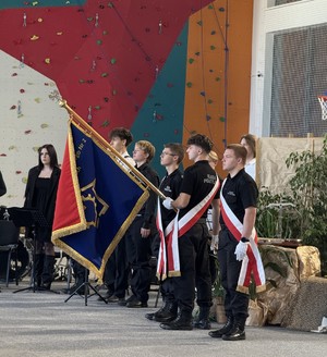 Uczniowie klasy policyjnej trzymający w ręku sztandar szkoły