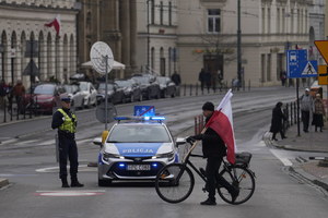 radiowóz ruchu drogowego i policjant, który zabezpiecza wjazd na plac studzińskiego