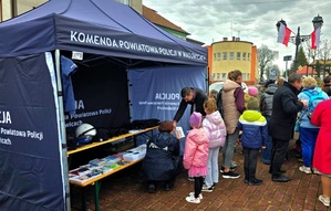 Namiot policyjny a obok grupa osób.