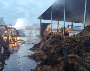 słoma i siano obok słuzby ratunkowe wokół nich dym