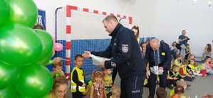 Policjant wręcza dzieciom odblaski