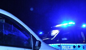 KPP Oświęcim Kontrola drogowa  w noc radiowóz na sygnałach obok samochód