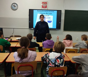 umundurowana policjantka stoi przed dziećmi w sali lekcyjnej