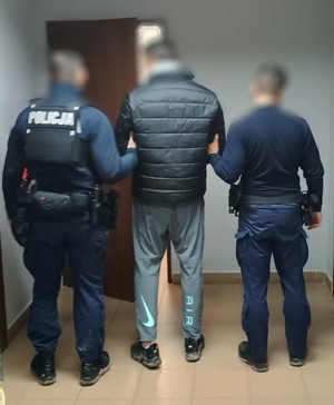 Dwóch policjantów pomiedzy nimi zatrzymany mezczyzna
