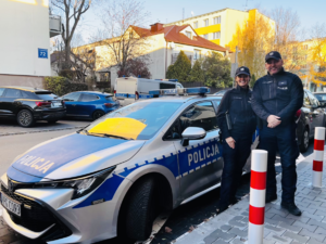 policjanci stoją przy radiowozie