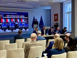 Naczelnik WRD stojąc przy mównicy omawia stan bezpieczeństwa na małopolskich drogach. Na sali uczestnicy spotkania