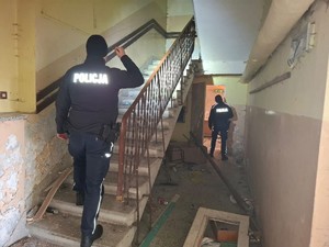 Dwóch policjantów na klatce schodowej pustostanu