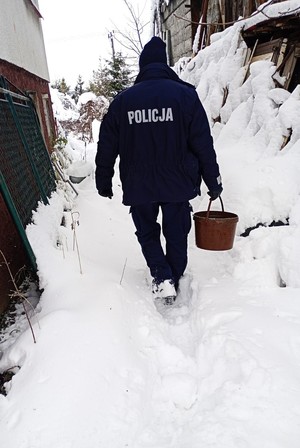 policjant niesie wiadro z wodą