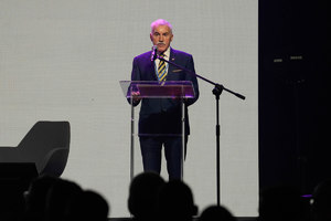 Przemawiający do zgromadzonych gości mężczyzna przy mównicy