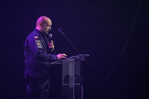 Przemawiający prelegent stojący przy mównicy