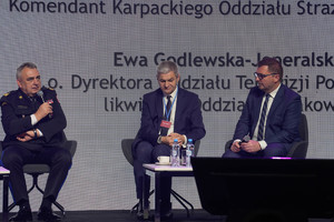 Dyskusja zaproszonych prelegentów, jeden z mężczyzn trzyma mikrofon