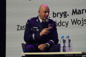 Przemawiający prelegent z Komendy Głownej Policji, umundurowany policjant