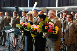 soliści z dyrygentem trzymają wręczone im wiązanki kwiatów