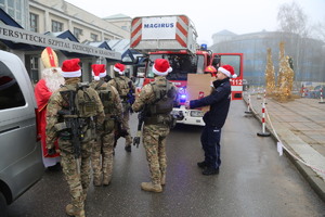 policjanci SPKP i strażacy PSP KW wynoszący paczki
